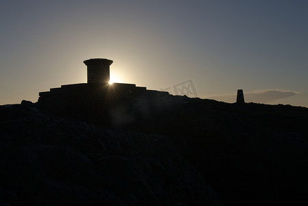 路灯塔摄影照片_日出时从伍斯特郡灯塔的拓扑镜后射出的太阳耀斑