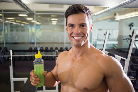 运动型年轻人在健身房喝能量饮料