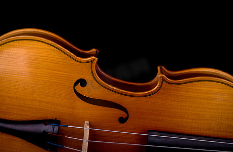玩乐器摄影照片_孤立在黑色的小提琴乐器特写