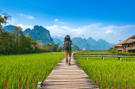 背着背包走在老挝万荣木路上的旅游