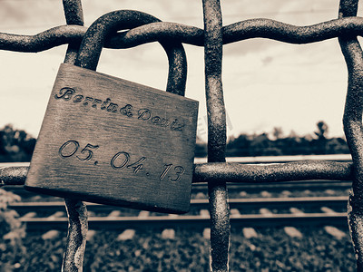 安全栏杆摄影照片_锁在栏杆上的旧生锈挂锁的单色特写