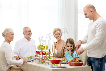 节日家人摄影照片_微笑的家人在家吃节日晚餐