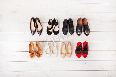 不同的夏季女鞋在木制的白色地板上。