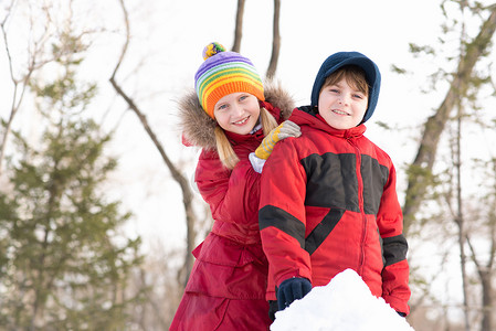 男孩和女孩在冬季公园玩雪