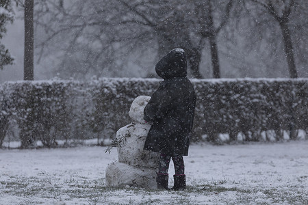 玩雪摄影照片_孩子们在马德里丽池公园玩雪和堆雪人。