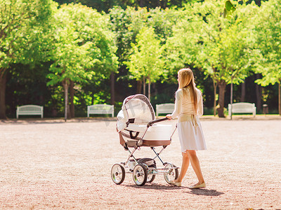 公园里推着婴儿车的快乐妈妈