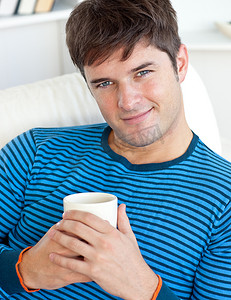 休息动画摄影照片_快乐的人拿着一杯咖啡躺在沙发上休息
