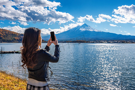 女人用手机在日本河口湖富士山拍照。