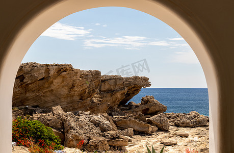 从希腊罗得岛 Kallithea Spring 的 Kallithea Therms 岩石海岸线上的拱门望去