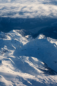 蓝色的直升飞机摄影照片_“加拿大不列颠哥伦比亚省白雪皑皑的山峰鸟瞰图”