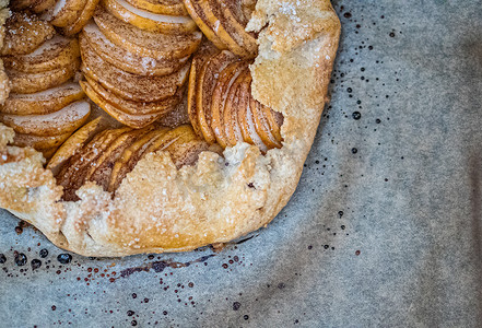苹果饼-烘烤羊皮纸和深色背景上的馅饼。