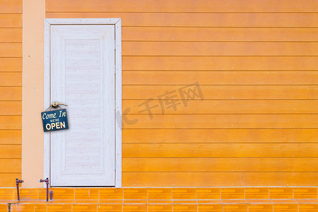 白色木门和带旧生锈金属板的橙色墙壁