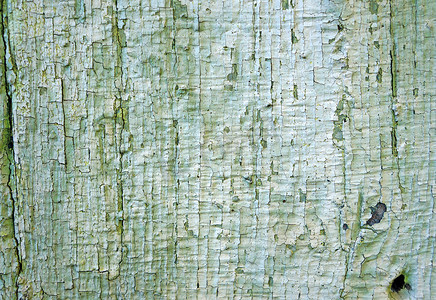 旧木墙的质地，上面有褪色的绿色片状油漆