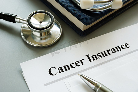 政策风险摄影照片_癌症保险政策和听诊器在书桌上。