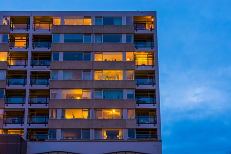 荷兰蒂尔堡的现代城市建筑，晚上有灯光窗户的公寓大楼