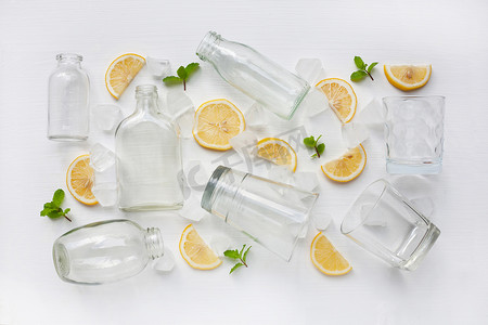 玻璃杯和饮料瓶，上面有柠檬片、薄荷和冰