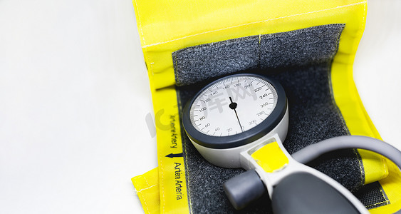 一种便携式血压计，固定在黄色袖口上，适合成人使用，带有魔术贴封口。