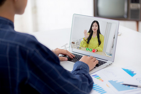 财务办公摄影照片_年轻的亚洲商人在笔记本电脑空白显示屏上工作，同时在办公桌上报告图形和图表纸，商人在桌子上分析财务统计数据，规划成功，室内。