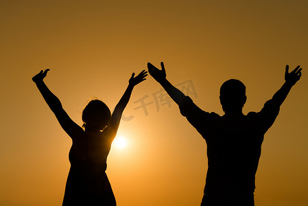 天恩摄影照片_恩爱的情侣在日落时举手享受