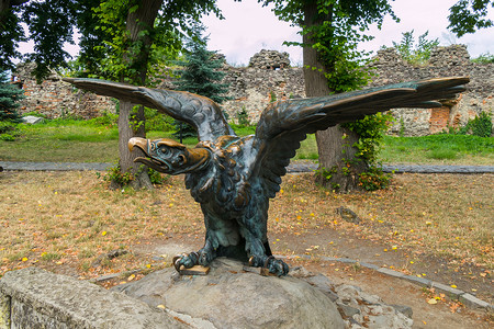 雕塑青铜摄影照片_公园里一只张开翅膀的鸟的青铜雕塑
