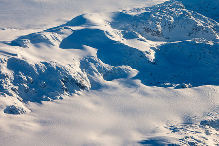 蓝色的直升飞机摄影照片_加拿大不列颠哥伦比亚省白雪皑皑的山峰鸟瞰图