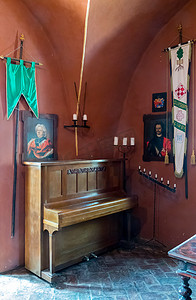 角落里装饰着一架旧钢琴、有图案的烛台和伟人的肖像。