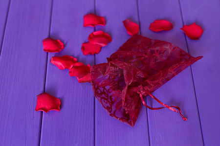 红色纱布摄影照片_透明硬纱袋和花瓣