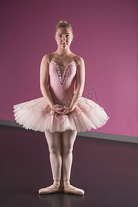可爱芭蕾摄影照片_站立在第一个位置的优美的芭蕾舞女演员