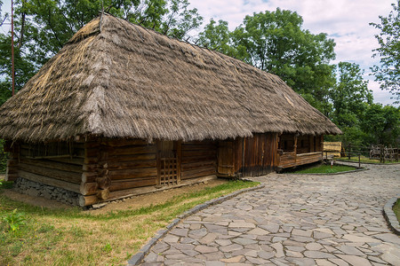 一个古老的乡村小屋，在一个覆盖着茅草屋顶的公园里