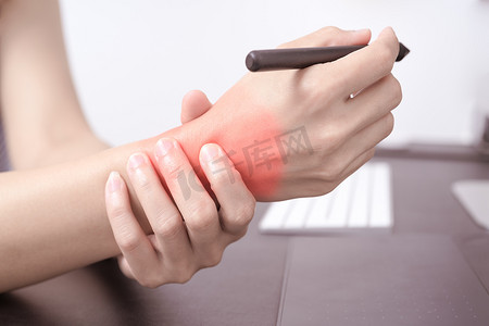 鼠标垫加鼠标摄影照片_女人手腕手臂疼痛长时间使用笔鼠标工作。