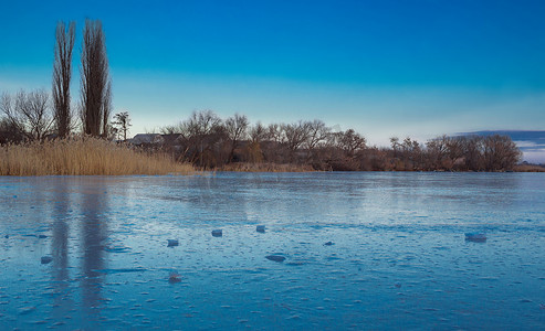 冰湖上结冰的雪村冬季风景