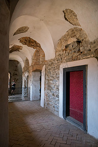 城堡走廊的门有厚厚的墙壁和拱门天花板。