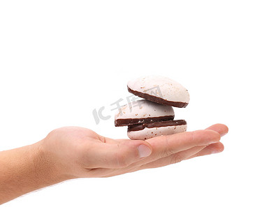 手中拿着巧克力的白色亲吻饼干。
