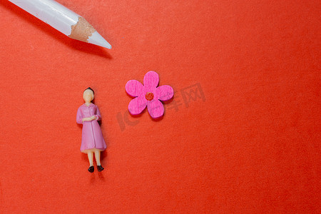 铅笔小图标摄影照片_红色背景中的女人雕像和假花图标和铅笔