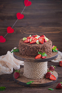 巧克力蛋糕蛋糕摄影照片_木制背景中带草莓的俄罗斯巧克力蛋糕拿破仑