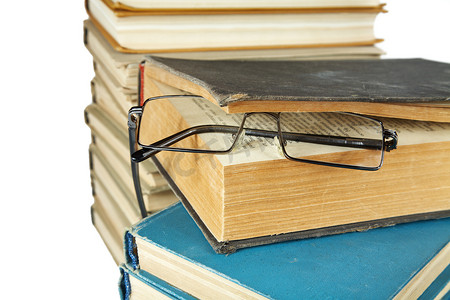一堆旧书和眼镜隔离在白色