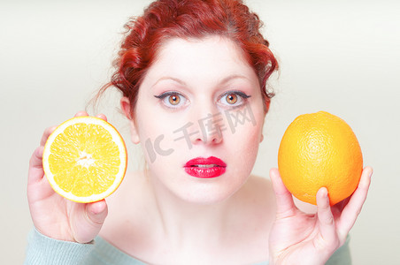美丽的多肉摄影照片_美丽的红头发和嘴唇的女孩与橘子