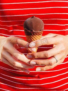 穿红衬衫的女人拿着冰淇淋。