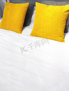 带亮黄色平绒靠垫的床