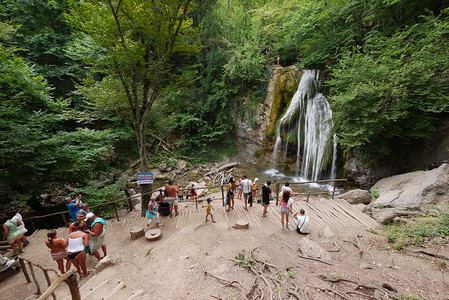 一群游客靠近一个小瀑布。