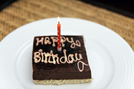 方形生日蛋糕摄影照片_小方形节日巧克力蛋糕，上面刻着快乐 b
