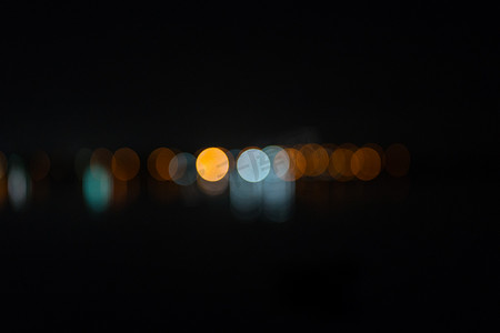 在黑暗的夜空背景下，远处抽象的散焦城市灯光