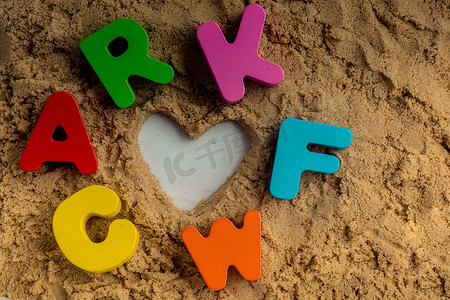 心形和彩色字母放在沙子上