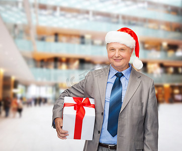 穿着西装的微笑男士和带礼物的圣诞老人助手帽