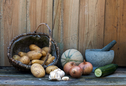 绿色藤条摄影照片_stil life with patatoes 洋葱和其他水果