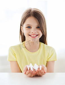 微笑的小女孩展示纸人家庭