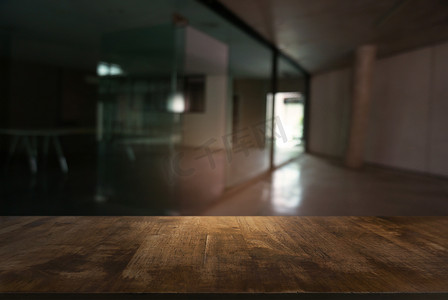 模糊窗户背景摄影照片_在抽象模糊的背景前的空木桌