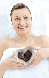 快乐的女人拿着一个心形碗和巧克力