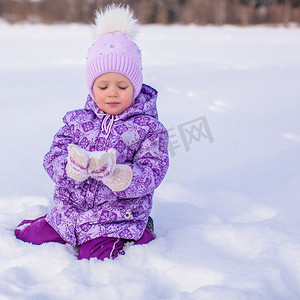 快乐的小女孩在冬天阳光明媚的日子里玩雪