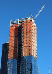 摩天大楼建筑工地已完成一半，顶部起重机